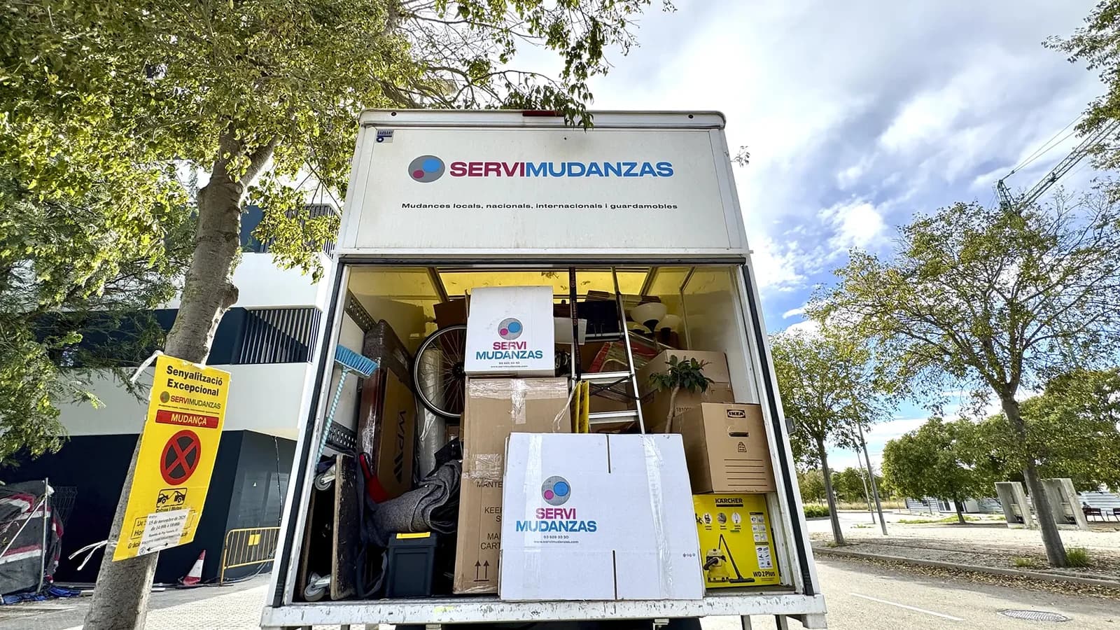 Camión cargado de Servimudanzas con cajas marca y cartel de señalización excepcional para mudanza