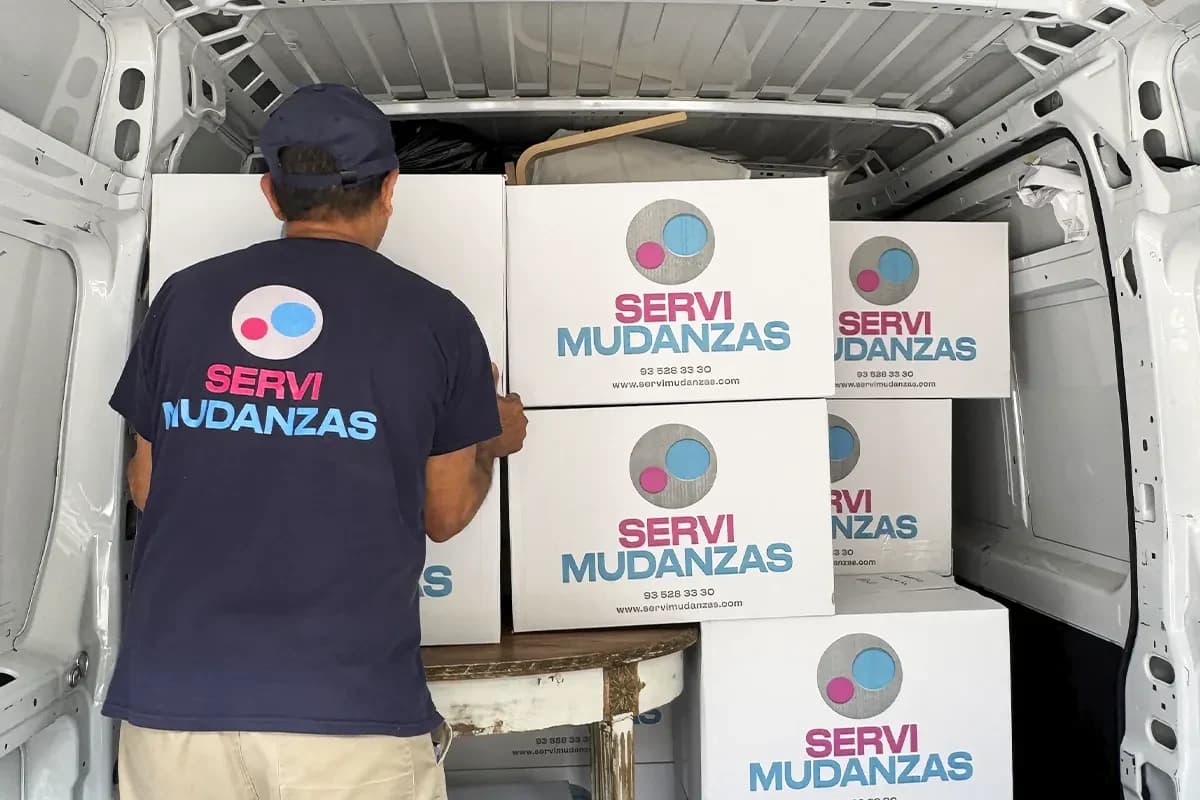 Operario de Servimudanzas apilando cajas marca dentro de furgoneta de mudanza
