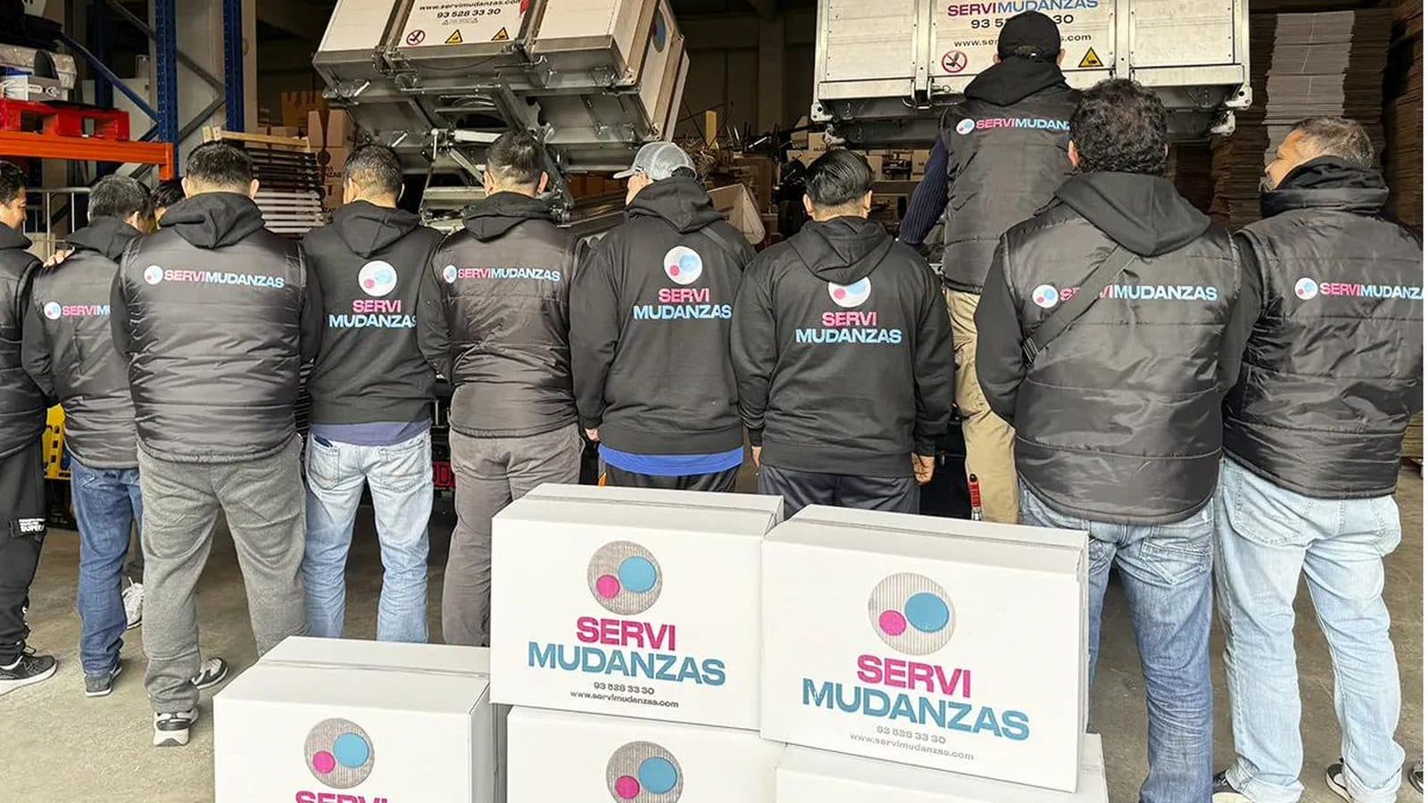 Operarios de mudanzas profesionales con uniforme cargando cajas en Barcelona