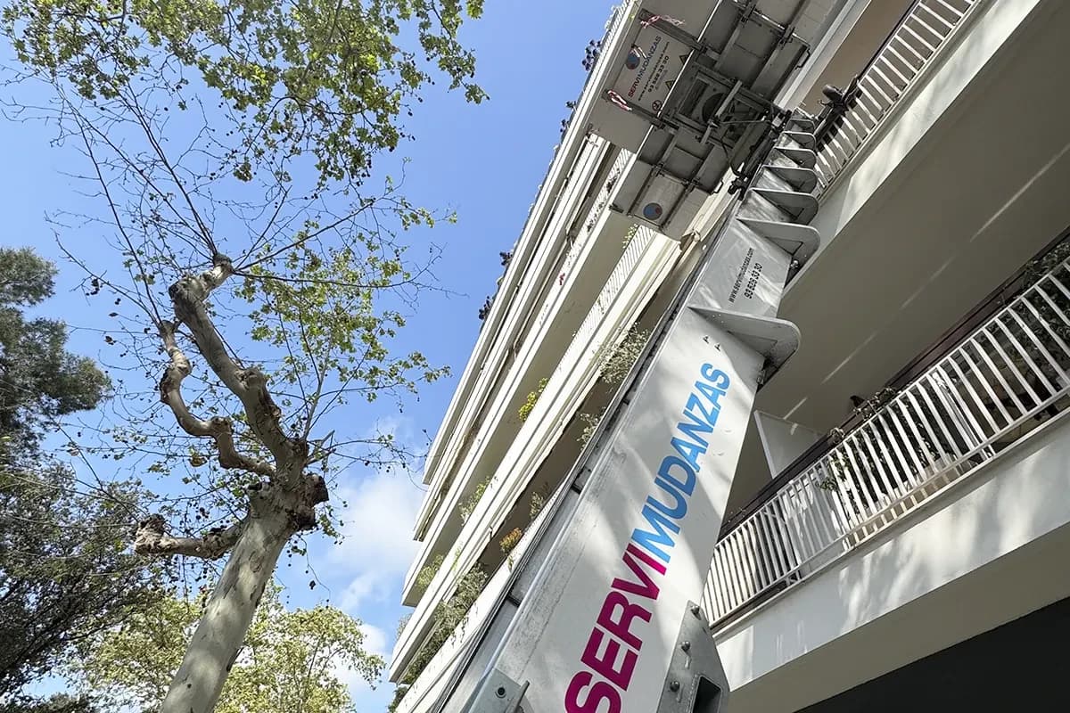 Mudanza con plataforma elevadora desplegada en fachada de edificio completo